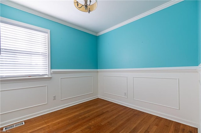 spare room featuring crown molding and wood-type flooring