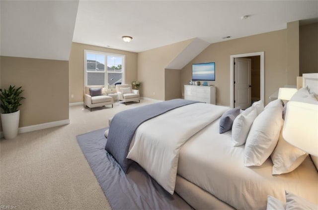 carpeted bedroom featuring vaulted ceiling and baseboards