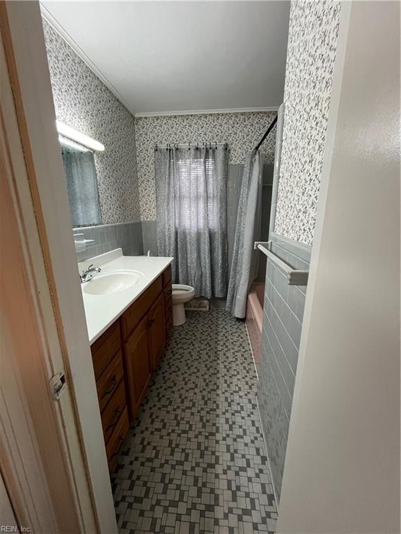 full bathroom with crown molding, shower / bath combo, toilet, tile walls, and vanity