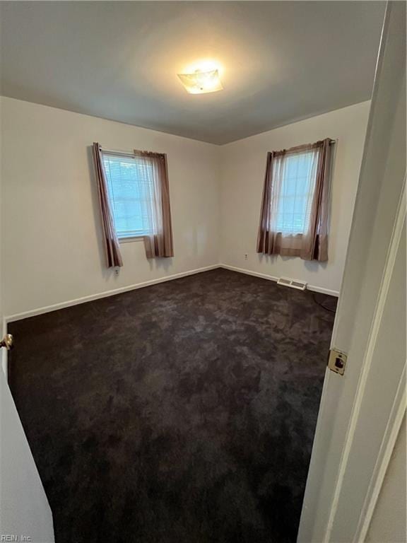 carpeted spare room featuring a healthy amount of sunlight