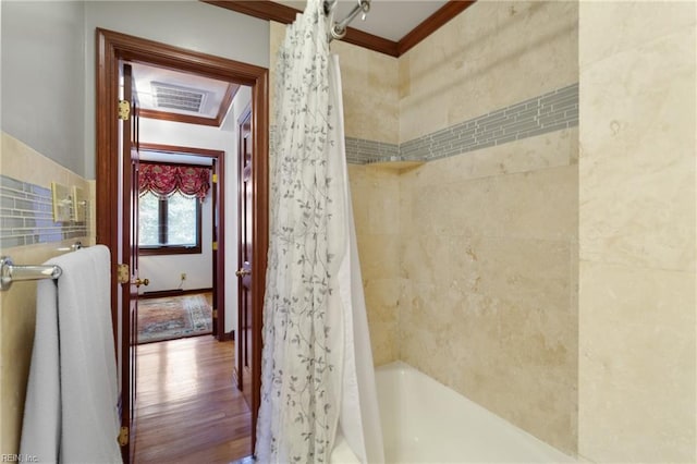 bathroom with hardwood / wood-style flooring, shower / bath combo, and ornamental molding