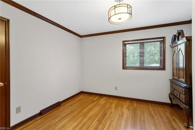 unfurnished room with light hardwood / wood-style floors and crown molding