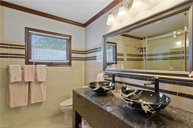 bathroom featuring crown molding, toilet, vanity, and tile walls