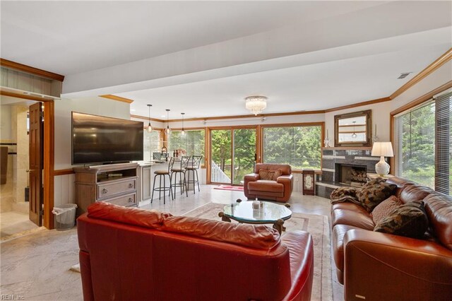 tiled living room with crown molding, plenty of natural light, and a high end fireplace