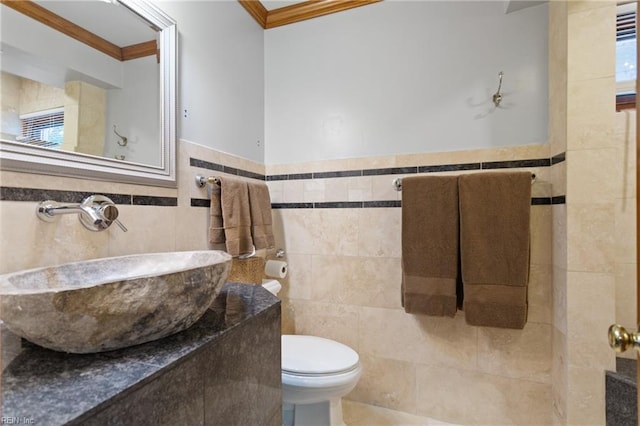 bathroom with tile walls, ornamental molding, sink, and toilet