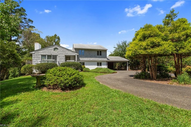 view of front of property with a carport and a front lawn