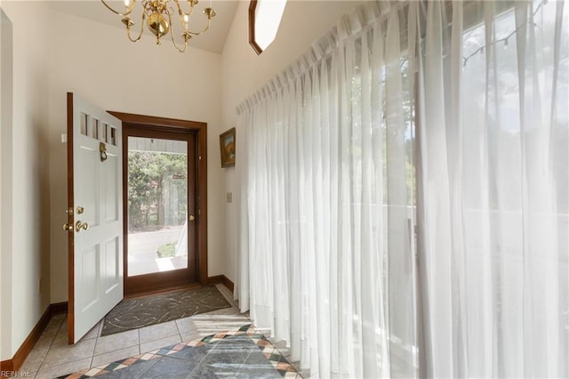 doorway featuring tile patterned floors, a notable chandelier, and vaulted ceiling