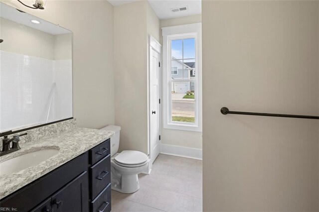 bathroom featuring tile patterned flooring, toilet, vanity, visible vents, and baseboards