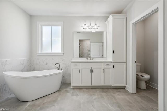 bathroom with toilet, vanity, tile patterned flooring, and tile walls