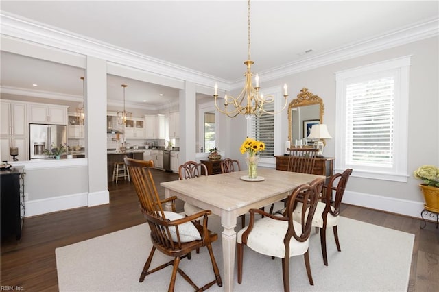 dining room with ornamental molding, dark wood finished floors, and an inviting chandelier