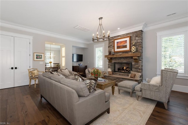 living room featuring ornamental molding, wood finished floors, a wealth of natural light, and a notable chandelier