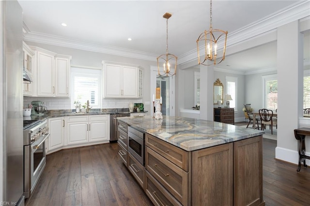 kitchen featuring white cabinetry, a chandelier, stainless steel appliances, light stone counters, and dark wood-type flooring