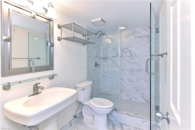 bathroom with a shower with door, toilet, a textured ceiling, and tile patterned floors