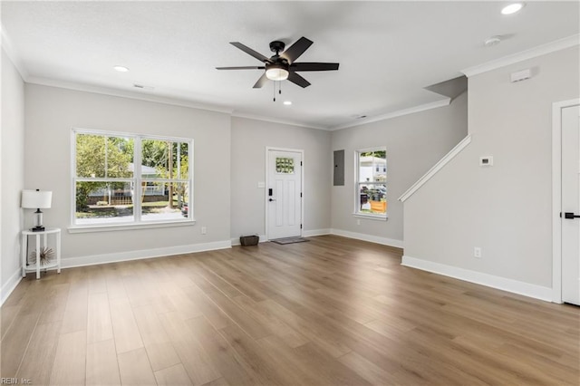 unfurnished living room with electric panel, light hardwood / wood-style flooring, ceiling fan, and crown molding