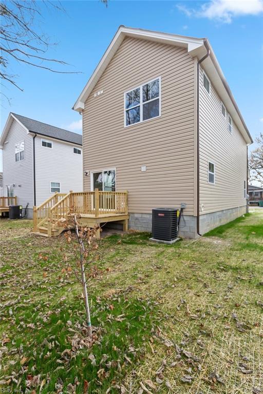 back of property with a yard, cooling unit, and a wooden deck