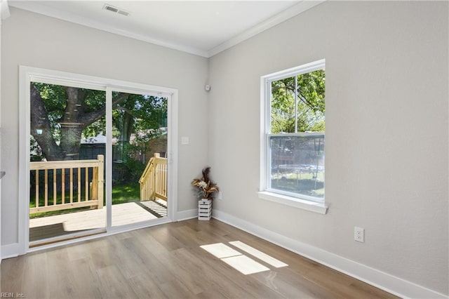 spare room featuring light hardwood / wood-style floors and crown molding