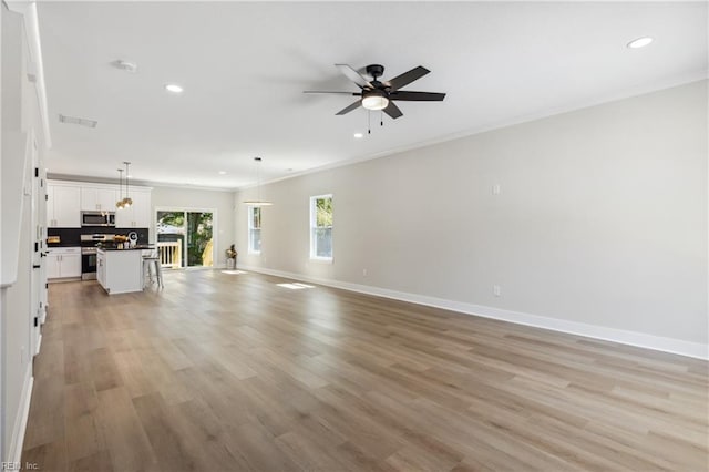 unfurnished living room featuring ceiling fan, crown molding, and light hardwood / wood-style floors