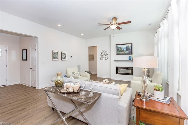 living room with light wood-type flooring and ceiling fan