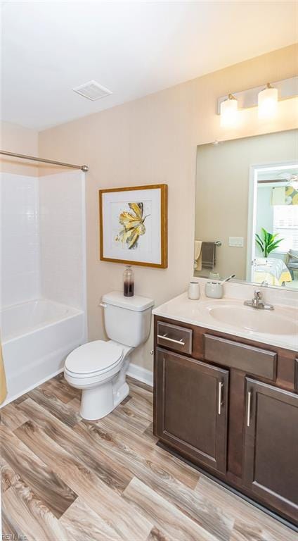 full bathroom featuring shower / bathtub combination, vanity, hardwood / wood-style floors, and toilet