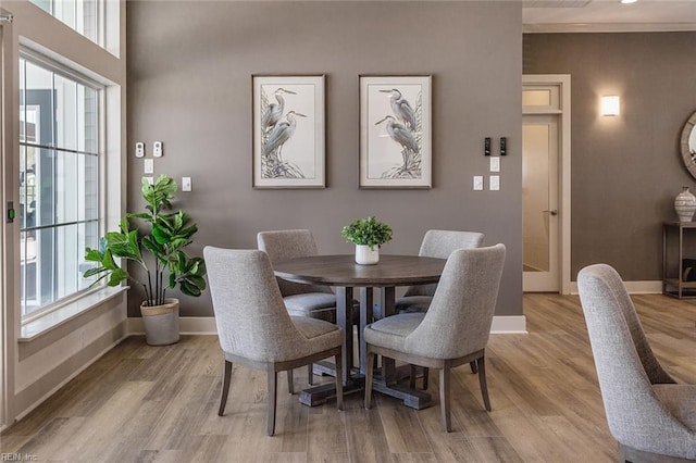 dining area with light wood-type flooring and a healthy amount of sunlight