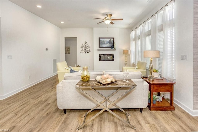 living room featuring light hardwood / wood-style flooring and ceiling fan