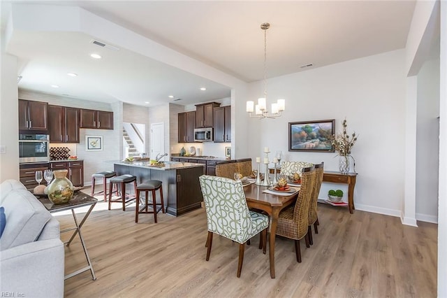 dining space featuring light hardwood / wood-style floors and a chandelier