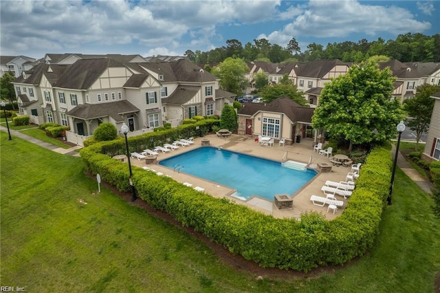 view of pool with a patio area and a lawn