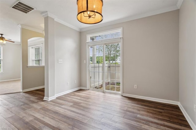 empty room featuring ornamental molding, hardwood / wood-style floors, and ceiling fan