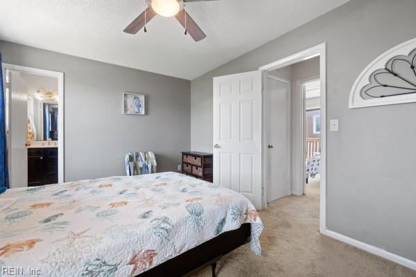 bedroom with ceiling fan, connected bathroom, and light colored carpet