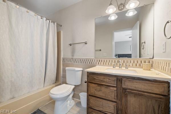 full bathroom with a chandelier, tile patterned flooring, vanity, shower / bath combo, and toilet