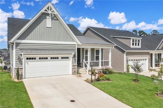 craftsman house with a porch, a garage, and a front lawn