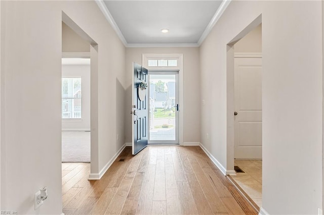 entryway with crown molding and light wood-type flooring