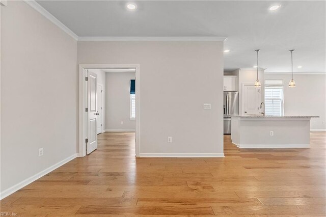 unfurnished living room featuring crown molding and light wood-type flooring