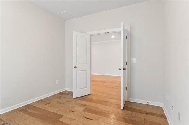 unfurnished living room with sink, light hardwood / wood-style flooring, and ornamental molding