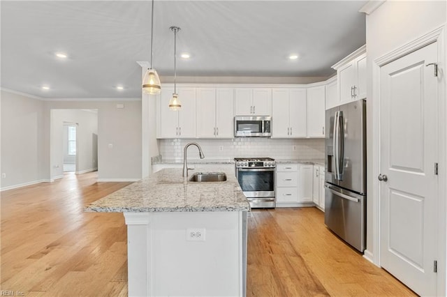 kitchen featuring stainless steel appliances, a kitchen island with sink, sink, and white cabinets