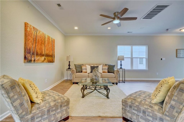 living room featuring ceiling fan, light wood-type flooring, and ornamental molding