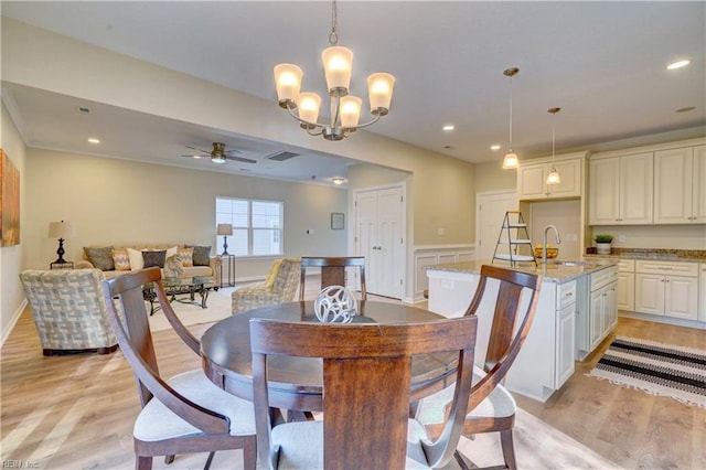 dining space with light wood finished floors, recessed lighting, ceiling fan with notable chandelier, and visible vents