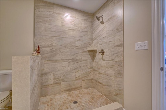 bathroom with toilet and a tile shower