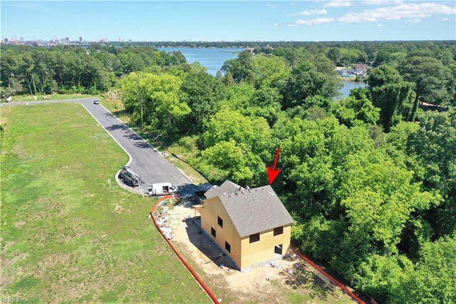 aerial view featuring a wooded view and a water view