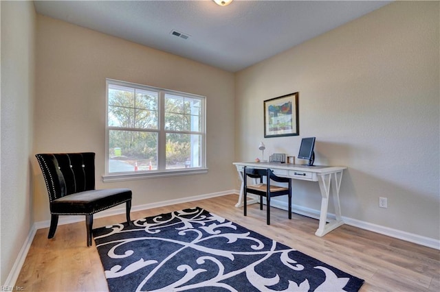 office area with visible vents, baseboards, and wood finished floors