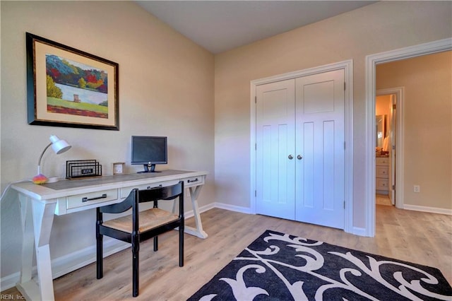 office area featuring light wood-type flooring and baseboards