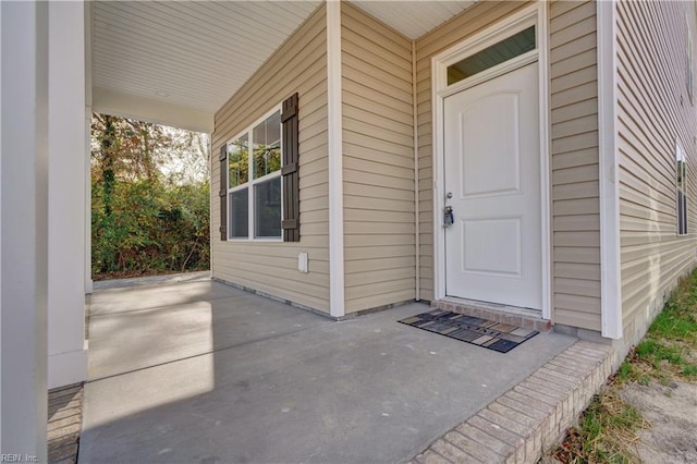 view of exterior entry featuring covered porch