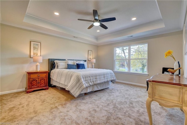 bedroom featuring a tray ceiling, baseboards, and light colored carpet