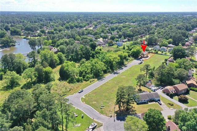 birds eye view of property with a water view and a wooded view