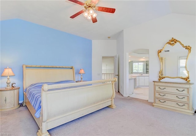 carpeted bedroom featuring ceiling fan, vaulted ceiling, and ensuite bath