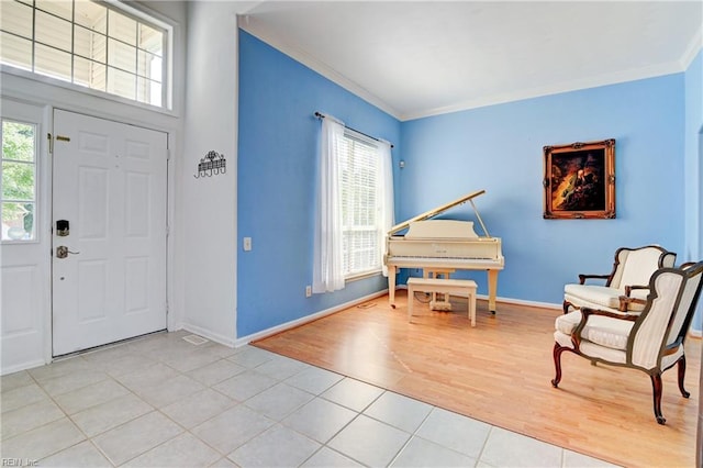 foyer with light tile patterned flooring and ornamental molding