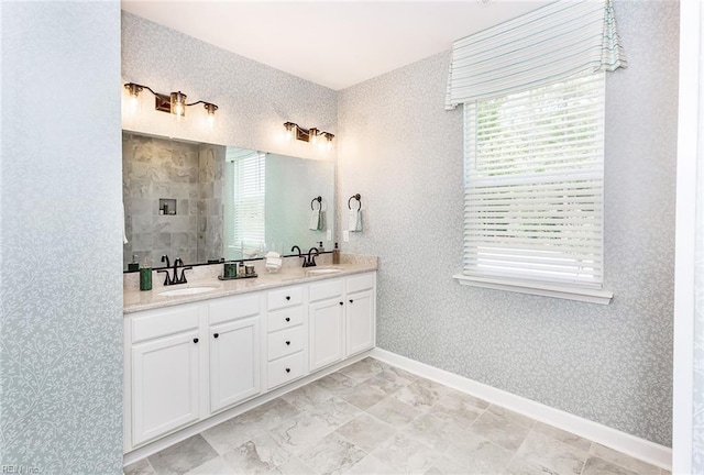 bathroom with a wealth of natural light, double sink vanity, and tile patterned floors