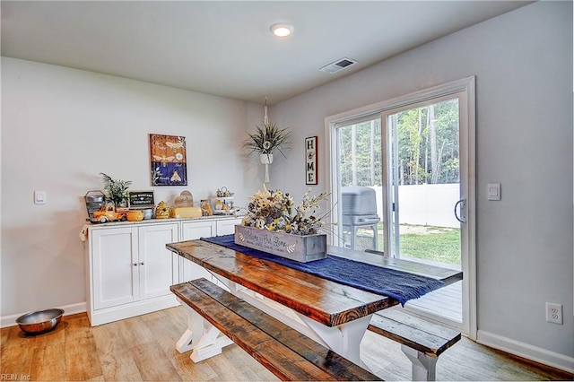 dining space with light wood-style floors, baseboards, visible vents, and a wealth of natural light