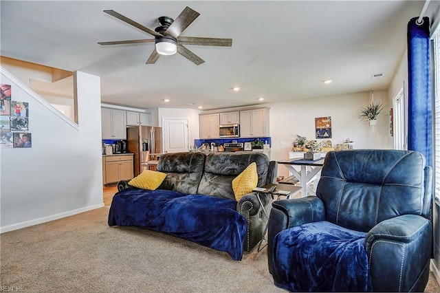 carpeted living room with ceiling fan