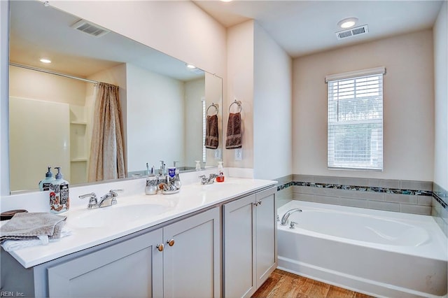 bathroom with independent shower and bath, vanity, and wood-type flooring